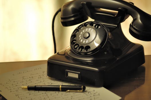 A nostalgic scene with an antique rotary phone and a fountain pen on a desk.